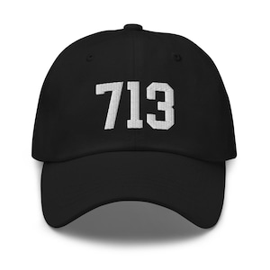 Puede incluir: Una gorra de béisbol negra con un "713" bordado en blanco en la parte delantera.