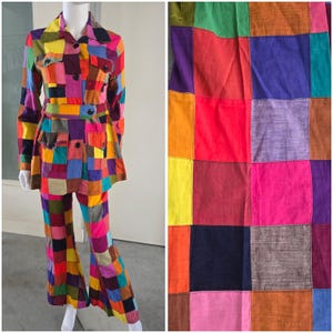 May include: A colorful patchwork suit, featuring a jacket with pockets and a matching pair of flared pants. The suit is made of various fabric squares in shades of red, yellow, blue, purple, and orange. The jacket has a belt.