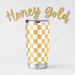 May include: A stainless steel tumbler with a yellow and white checkered pattern. The words "Honey Gold" are written in a cursive font above the tumbler. The tumbler has a silver base and a lid.