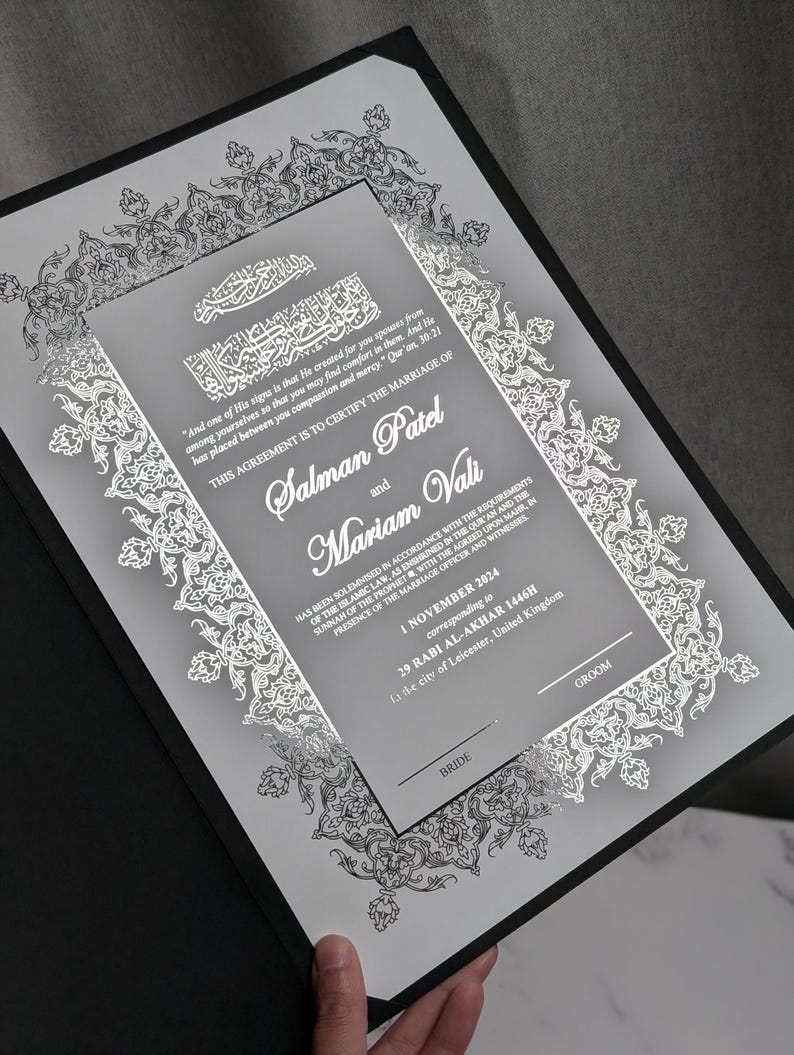 May include: A marriage certificate with silver filigree and text, including the names Salman Patel and Mariam Vali. The date is 1 November 2024, in Leicester, United Kingdom. The certificate is presented in a black folder with decorative borders.