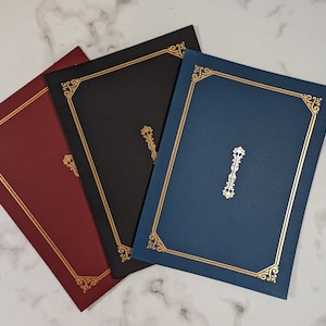 May include: Three document holders in burgundy, black, and navy blue, each with a gold border and decorative corner accents. A gold emblem is centered on each holder, creating a classic and elegant design.