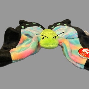 May include: A green and black butterfly plush toy with a rainbow-colored pattern on its wings. The toy has a red and white Ty tag attached to it.