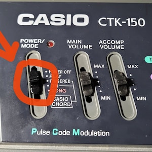 May include: Close-up of a Casio CTK-150 keyboard with a black switch labelled "Power/Mode" and a red LED light. The switch has four positions: "Power Off", "Play", "Fingered", "Song", and "Casio Chord".