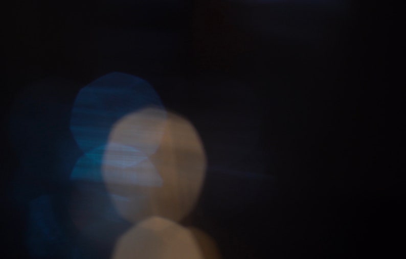 Puede incluir: Fondo abstracto con luces desenfocadas fuera de foco en tonos de azul y blanco sobre un fondo negro.