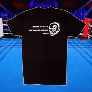 Könnte beinhalten: Schwarzes T-Shirt mit einem weißen Grafikdruck eines Männergesichts und dem Text "I broke my back, my back is broken, spinal".