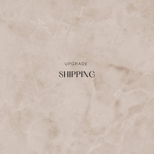 May include: A beige marble background with the text "UPGRADE SHIPPING" in black.