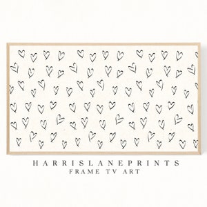 Pu&ograve; includere: Una stampa incorniciata con sfondo bianco e un motivo di cuori neri disegnati a mano. La stampa ha il testo "HARRISLANEPRINTS FRAME TV ART" in basso.