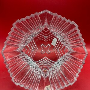 May include: A clear glass bowl with a geometric design. The bowl has a starburst pattern and is made in France.