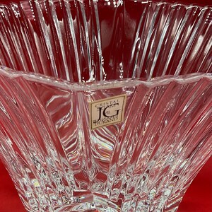 May include: A clear glass bowl with a star-shaped base and a textured, ribbed design. The bowl has a label that reads "Cristal d'Arques J.G. Durand".