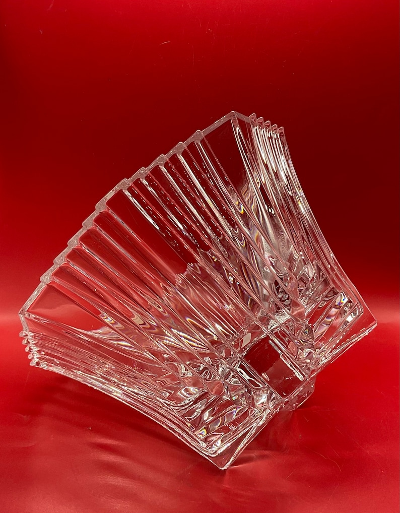 May include: A clear glass bowl with a geometric design. The bowl is made of crystal and has a square shape. The bowl is perfect for serving fruit, snacks, or other treats.