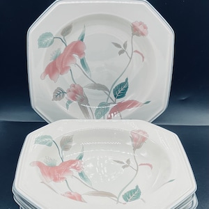 May include: A stack of eight white octagonal soup bowls with a floral design featuring pink flowers and green leaves.