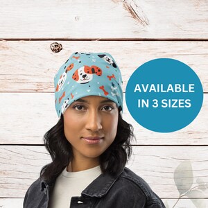 May include: A blue beanie with a pattern of cartoon dogs and bones. The beanie is available in three sizes. AVAILABLE IN 3 SIZES.