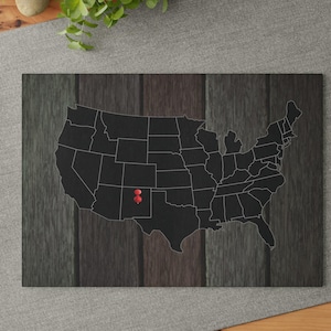 May include: A black and white map of the United States with a red push pin marking a location in the state of Utah.