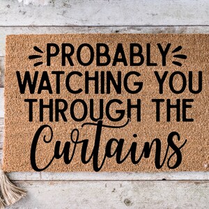 May include: A brown doormat with the text "PROBABLY WATCHING YOU THROUGH THE CURTAINS" in black lettering.