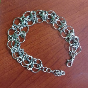 May include: A silver chain bracelet made of interlocking circles.