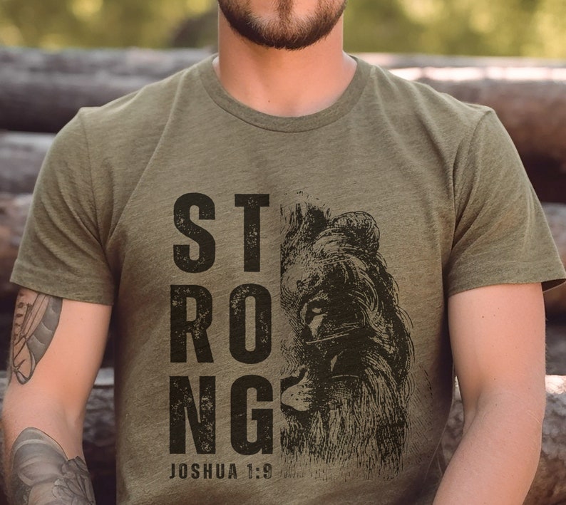 May include: A green t-shirt with a distressed black graphic of a lion's face and the word "STRONG" with the text "Joshua 1:9" below.
