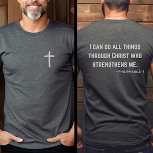 May include: A dark grey t-shirt with a white cross on the front and the text "I CAN DO ALL THINGS THROUGH CHRIST WHO STRENGTHENS ME. - PHILIPPIANS 4:13" on the back.