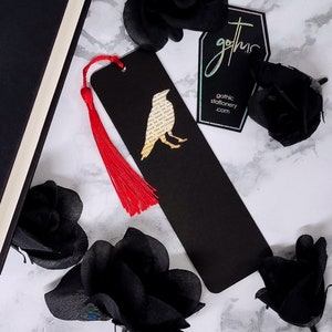 Handmade bookmark inspired by Edgar Allan Poe's poem The Raven. A raven shape cut from on each side of black card reveals a yellowed and aged section of text from the iconic horror classic, and is finished off with a silky red tassel.