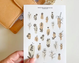 May include: A sheet of stickers with a white background and 20 different floral designs. The stickers are in shades of brown, beige, and white. The text "DECO KOLLECTION N°28 KOLOUR CAFE" is at the top of the sheet. The text "DK-28" is at the bottom of the sheet.