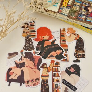 May include: A set of six illustrated stickers featuring women reading books. The stickers are colorful and feature a variety of scenes, including a woman reading in a cozy armchair, a woman reading in a library, and a woman reading in a bookstore. The stickers are perfect for adding a touch of whimsy to your planner, laptop, or water bottle.