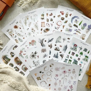 May include: A set of 10 sheets of watercolor stickers featuring various illustrations. The stickers include images of flowers, leaves, moons, owls, houses, and more. The stickers are printed on clear, glossy paper and are perfect for adding a touch of whimsy to your planner, journal, or scrapbook.
