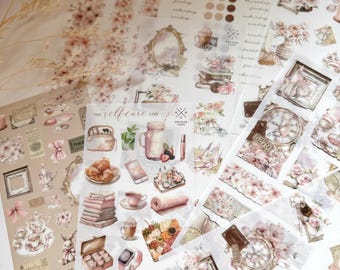 Puede incluir: Un conjunto de hojas de pegatinas transparentes con varias ilustraciones. Las pegatinas tienen un tema floral con colores rosa pastel y marrón. Las pegatinas incluyen imágenes de relojes, tazas de té, libros y otros elementos decorativos. El texto "The Selfcare Edit" es visible en una de las hojas.