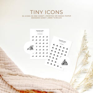 Könnte beinhalten: Zwei Blätter Washi-Papier mit jeweils 35 kleinen Icons bedruckt. Die Icons haben einen Durchmesser von 8 mm und sind in einem Raster angeordnet. Die Icons beinhalten einen Schwimmer, einen Radfahrer und andere Designs. Der Text "KOLOUR CAFE" ist auf jedem Blatt gedruckt.