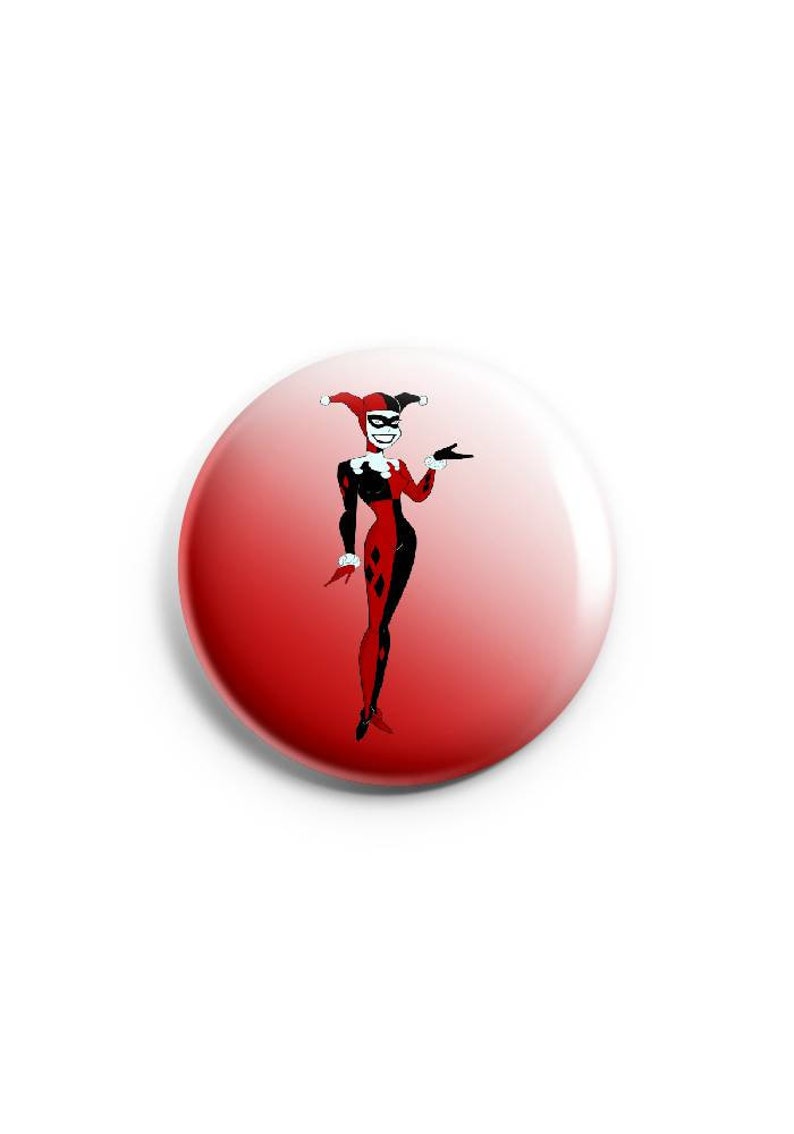 May include: A red and white button with a cartoon image of Harley Quinn wearing a jester's hat and costume.