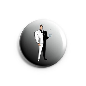 May include: A black and white button with a cartoon image of Two-Face from Batman. Two-Face is wearing a white suit and a black suit, with a line down the middle of his face.