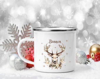 Könnte beinhalten: Weiße Email Tasse mit einer braunen und weißen Hirsch-Illustration und dem Namen Bianca auf der Vorderseite. Die Tasse ist von weißen und silbernen Weihnachtsdekorationen umgeben.