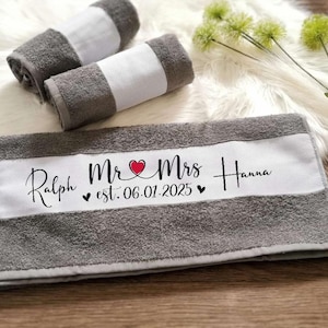 Könnte beinhalten: Graues und weißes Badetuch mit dem Text "Ralph & Mrs. Hanna est. 06.01.2025" in Schwarz mit einem roten Herzen gestickt.