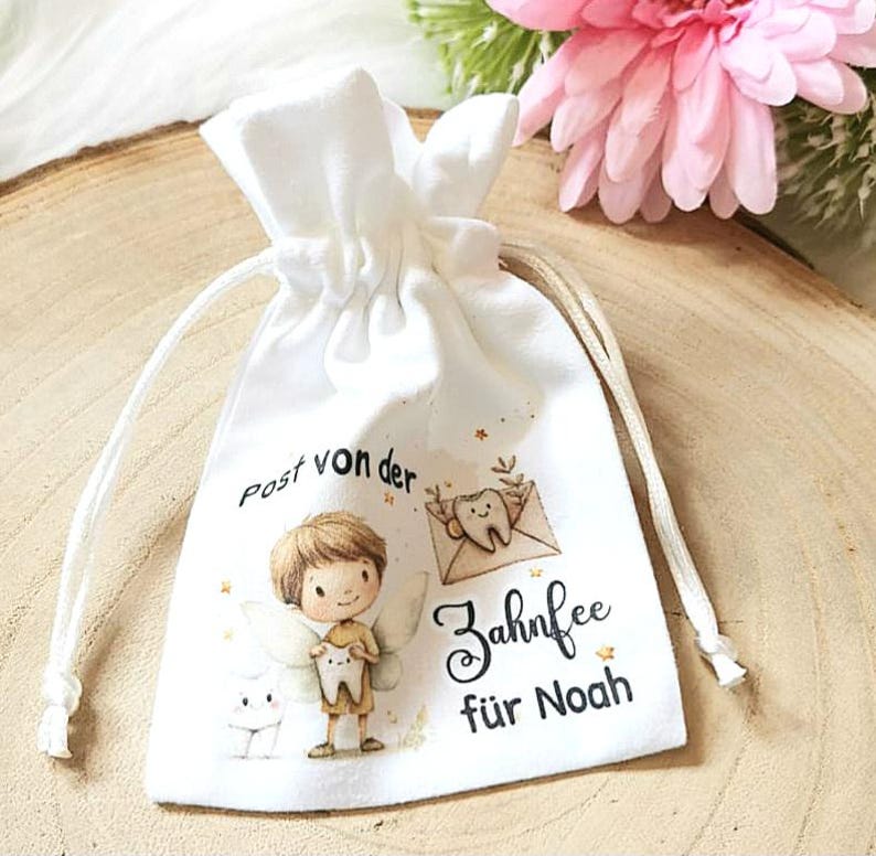 May include: White drawstring bag with a tooth fairy illustration and the text "Post von der Zahnfee f&uuml;r Noah".