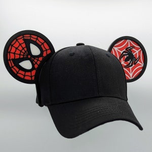 May include: Black baseball cap with red and black spider web and spider design on the sides. The cap has a black brim and a black crown.