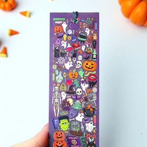 Puede incluir: Un marcap&aacute;ginas morado con ilustraciones de Halloween, incluyendo calabazas, fantasmas y sombreros de bruja. El marcap&aacute;ginas tiene una cuerda verde y las palabras "Trick or Treat". Calabazas naranjas y caramelos est&aacute;n esparcidos.