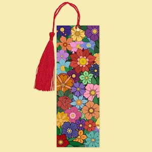 Pode incluir: Marcador de livros retangular com um design floral vibrante em várias cores, incluindo vermelho, amarelo, azul e roxo. O marcador de livros tem uma borla vermelha presa no topo com um cordão vermelho a condizer.
