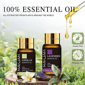 Może przedstawiać: Dwa małe, bursztynowe butelki ze szklanymi korkami, zawierające olejki eteryczne z wanilii i lawendy. Butelki są oznaczone etykietą "MAYJAM" i mają napis "100% Olejek Eteryczny, Jakość Terapeutyczna" oraz "5 ml". Butelki stoją na drewnianej powierzchni, na tle zielonej roślinności. Obrazek zawiera również dwie okrągłe etykiety w kolorze zielonym i białym, z napisem "Cruelty Free" i "Phthalate Free".