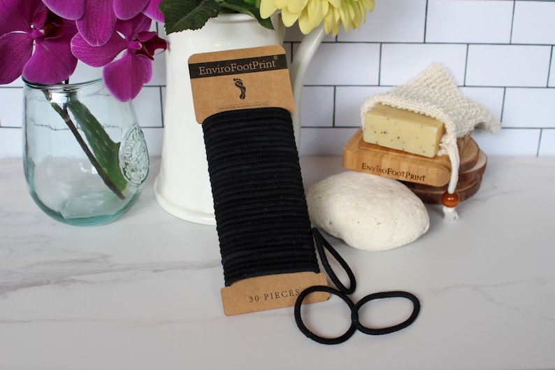 May include: A pack of 30 black hair elastics, labelled "EnviroFootPrint" and "30 PIECES".