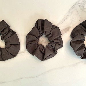 May include: Three dark brown fabric scrunchies.