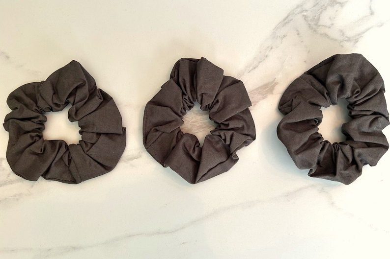 May include: Three dark brown fabric scrunchies.