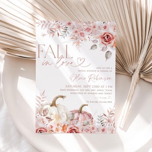 May include: Fall in love bridal shower invitation with a watercolor floral design featuring pumpkins and roses in shades of pink, peach, and white. The invitation includes the text "Fall in love" and "Olivia Robinson".