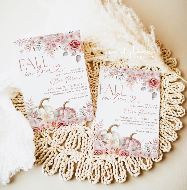 May include: Two fall-themed bridal shower invitations with a watercolor design featuring pumpkins, leaves, and flowers in shades of pink, peach, and green. The text on the invitations reads "Fall in love" and includes the bride's name, date, time, and location of the shower.