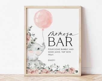 May include: A printable sign for a mimosa bar with a pink balloon and a cute elephant illustration. The sign says "Momoja Bar" and includes instructions to pour some bubbly and juice, top with fruit, and enjoy.