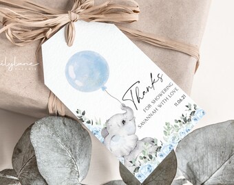 May include: A gift tag with a watercolor illustration of a baby elephant holding a blue balloon. The tag reads "Thanks for showering Savannah with love" and the date "11.06.21". The tag is decorated with blue flowers and greenery.