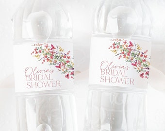 May include: Two clear plastic water bottles with white labels featuring a watercolour floral design. The labels have the text "Olivia's Bridal Shower" in pink.