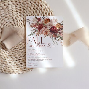 May include: Fall in love bridal shower invitation with a watercolor floral design in shades of pink, red, and orange. The invitation features the text "Fall in love" in a bold, red font. The invitation also includes the date, time, and location of the shower.