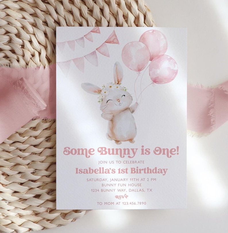 Op de afbeelding: Een roze en witte uitnodigingskaart met een aquarel-illustratie van een konijn dat roze ballonnen vasthoudt. De tekst luidt "Some Bunny is One!" en "Isabella's 1st Birthday".