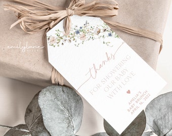 Puede incluir: Una etiqueta de agradecimiento blanca con un diseño floral en la parte superior. El texto dice "Gracias por celebrar a nuestro bebé con amor" y "Baby Brunch de Amelia 16 de abril de 2022".