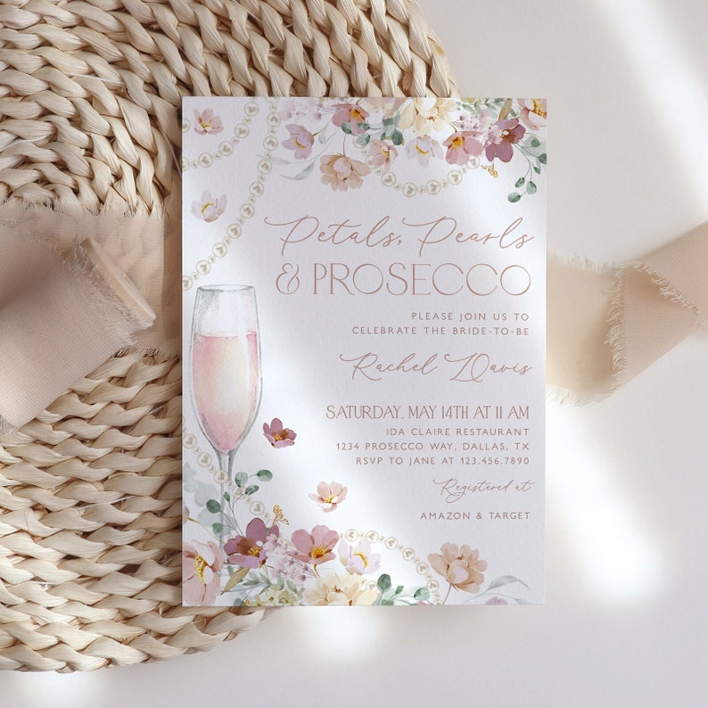 May include: A floral bridal shower invitation with a glass of pink prosecco, pearls, and the text "Petals, Pearls & Prosecco". The invitation is for Rachel Davis and includes the date, time, location, and RSVP information. It also states that the couple is registered at Amazon and Target.