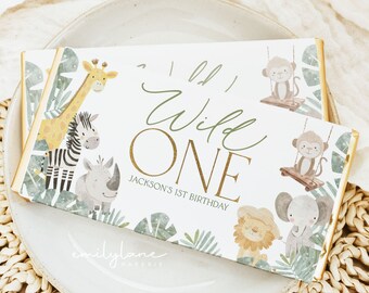 May include: A white chocolate bar wrapper with a jungle theme. It features a giraffe, zebra, rhino, lion, monkey, and elephant. The text on the wrapper reads "Oh Wild One" and "Jackson's 1st Birthday".
