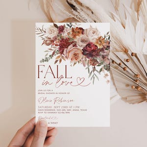 May include: Fall in love bridal shower invitation with a watercolor floral design in shades of burgundy, pink, and cream. The invitation features the text "Fall in love" with a heart.